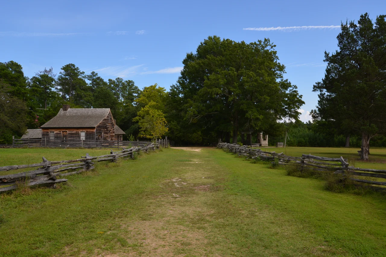 Bennett Place, a carefully reconstructed historic farm in Durham, North Carolina, the site of the largest surrender of Confederate soldiers during the American Civil War on April 26, 1865.  Showing, from left to right, the kitchen, the farmhouse, and the memorial monument.